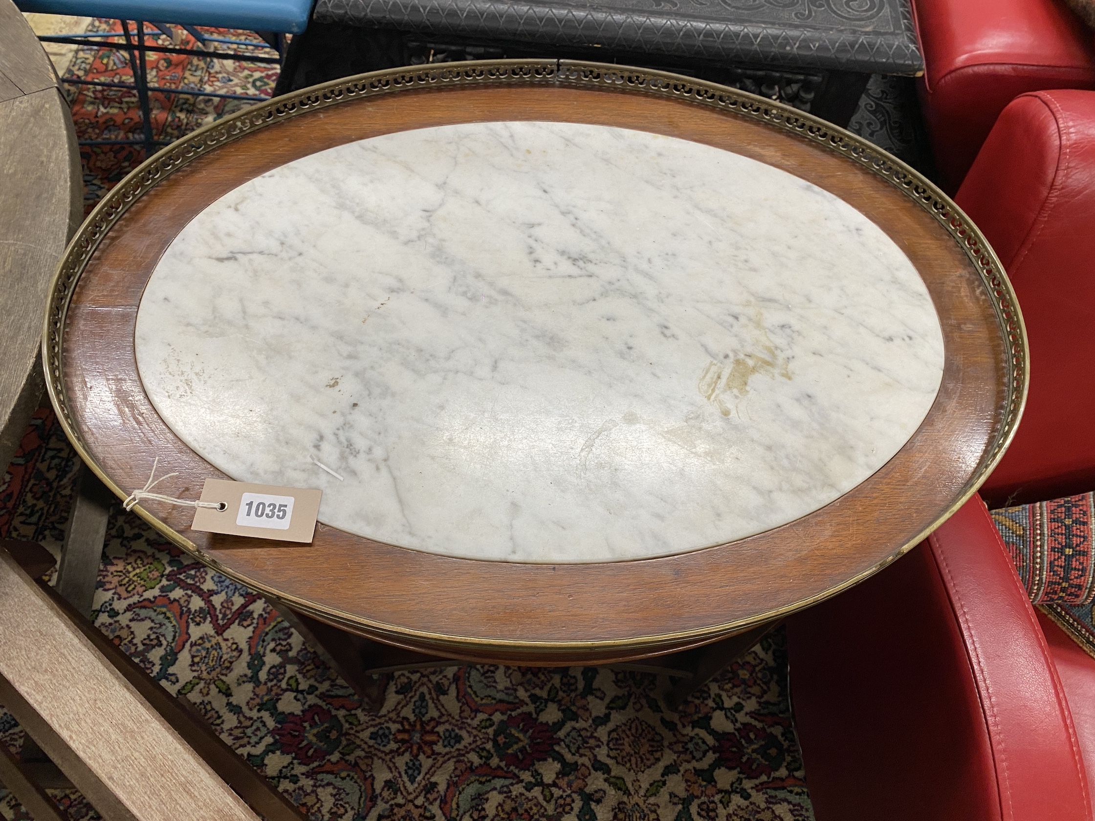 A Louis XVI style oval brass mounted marble topped two tier table, width 68cm, depth 48cm, height 74cm